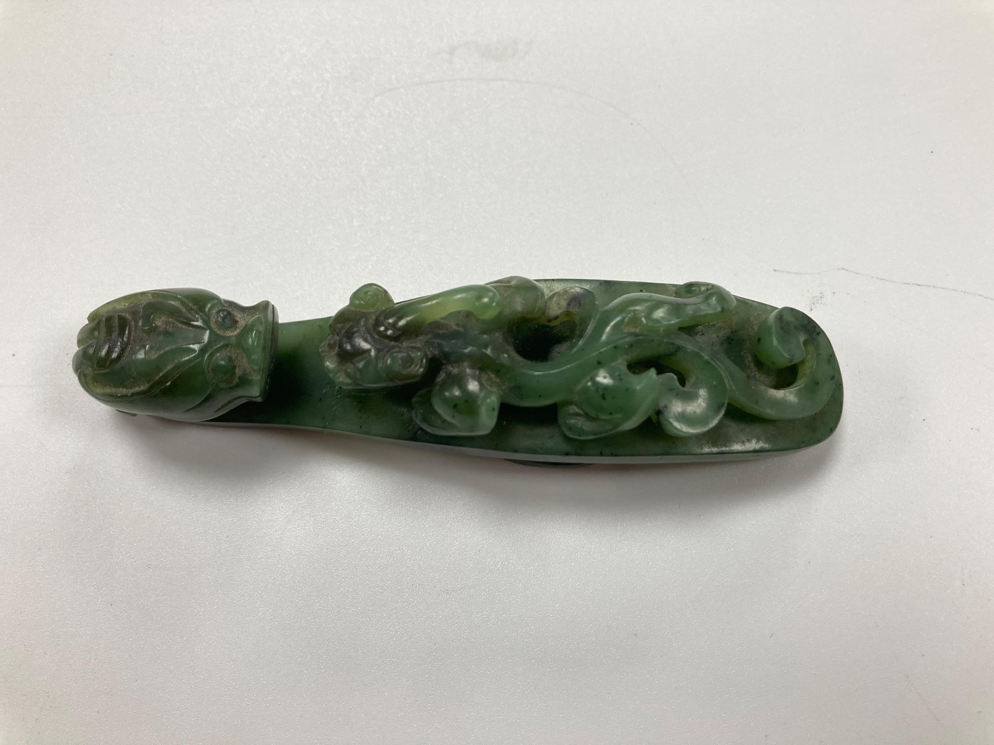 A Chinese bright spinach green jade ‘dragon’ belt hook, 18th/19th century, 9.5cm long